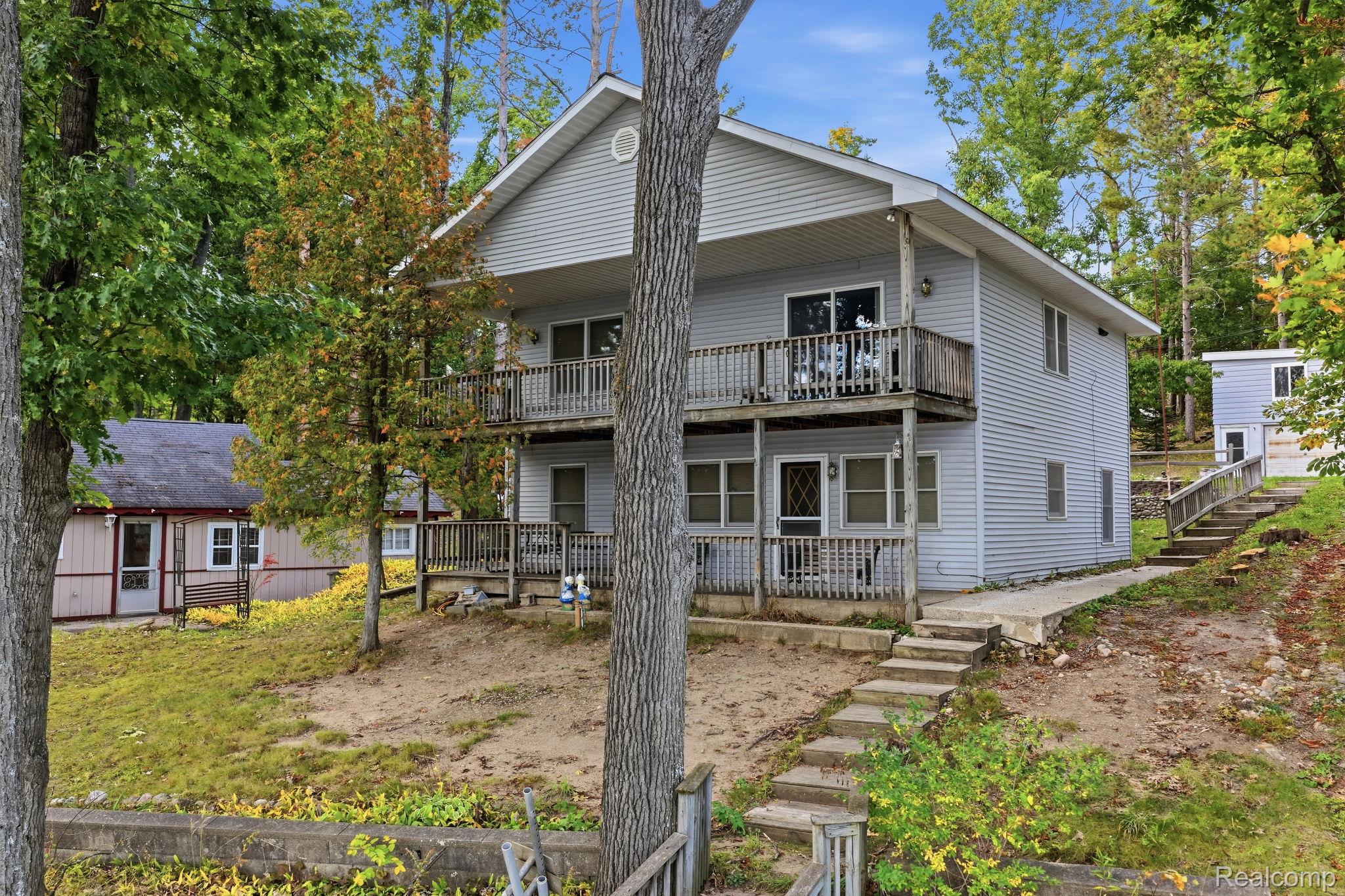 2259 Kassuba Road Gaylord, MI 49735 - Photo 1 of 46 Two-story property with light-colored siding, dual-level balconies, gabled roofline, and concrete steps