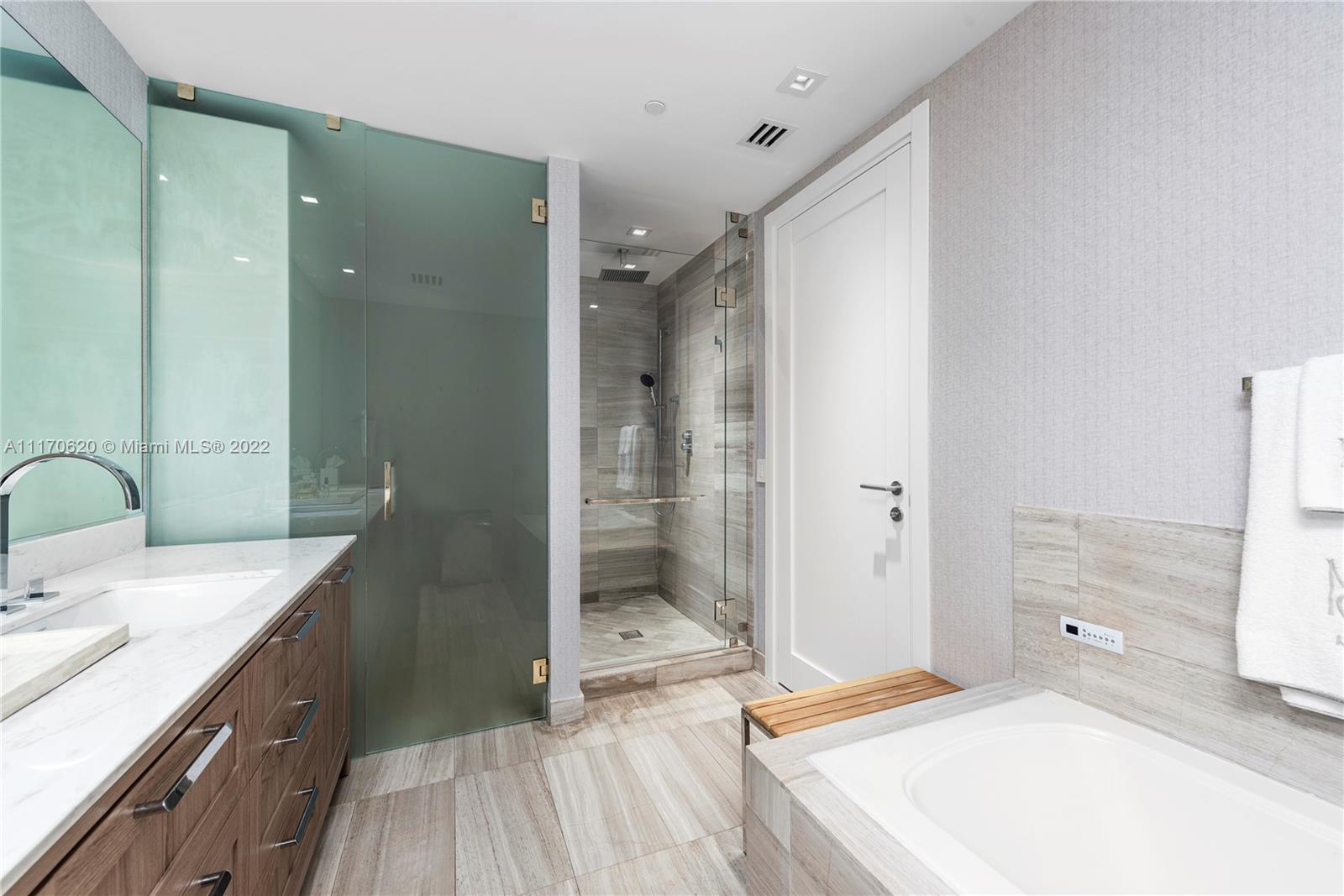 350 Ocean Drive, Unit 403N Key Biscayne, FL 33149 - Photo 27 of 55 a spacious bathroom with a shower sink and mirror