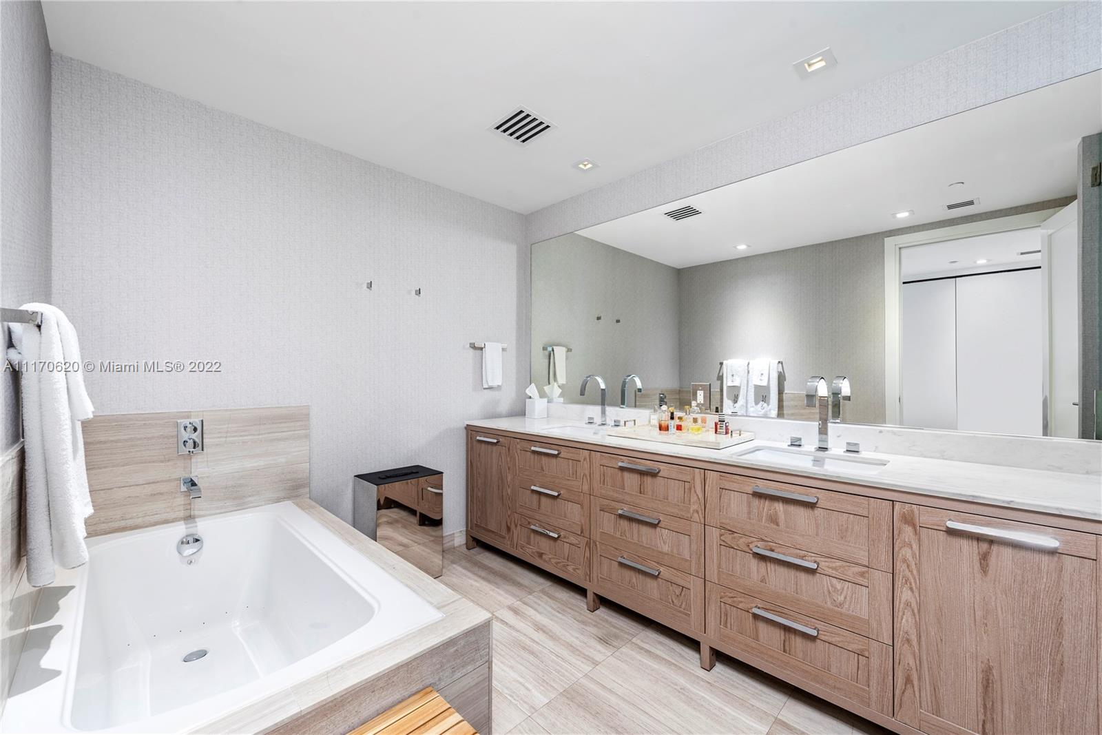 350 Ocean Drive, Unit 403N Key Biscayne, FL 33149 - Photo 28 of 55 a bathroom with a tub sink and mirror