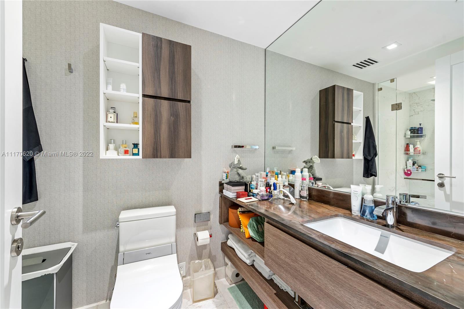350 Ocean Drive, Unit 403N Key Biscayne, FL 33149 - Photo 31 of 55 a bathroom with a sink mirror vanity and toilet