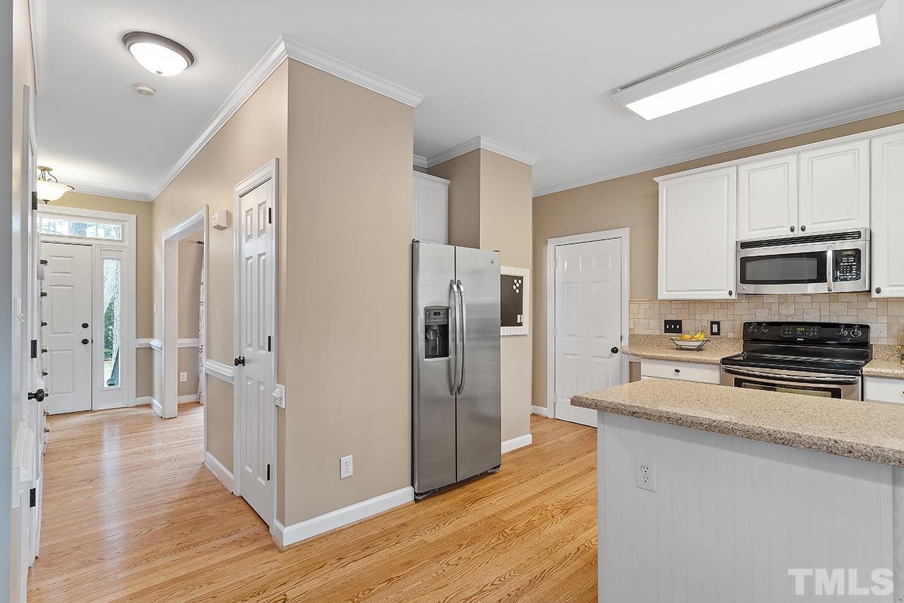 2625 Jasper Lane Raleigh, NC 27613 - Photo 18 of 40 a kitchen with granite countertop a refrigerator and a stove top oven