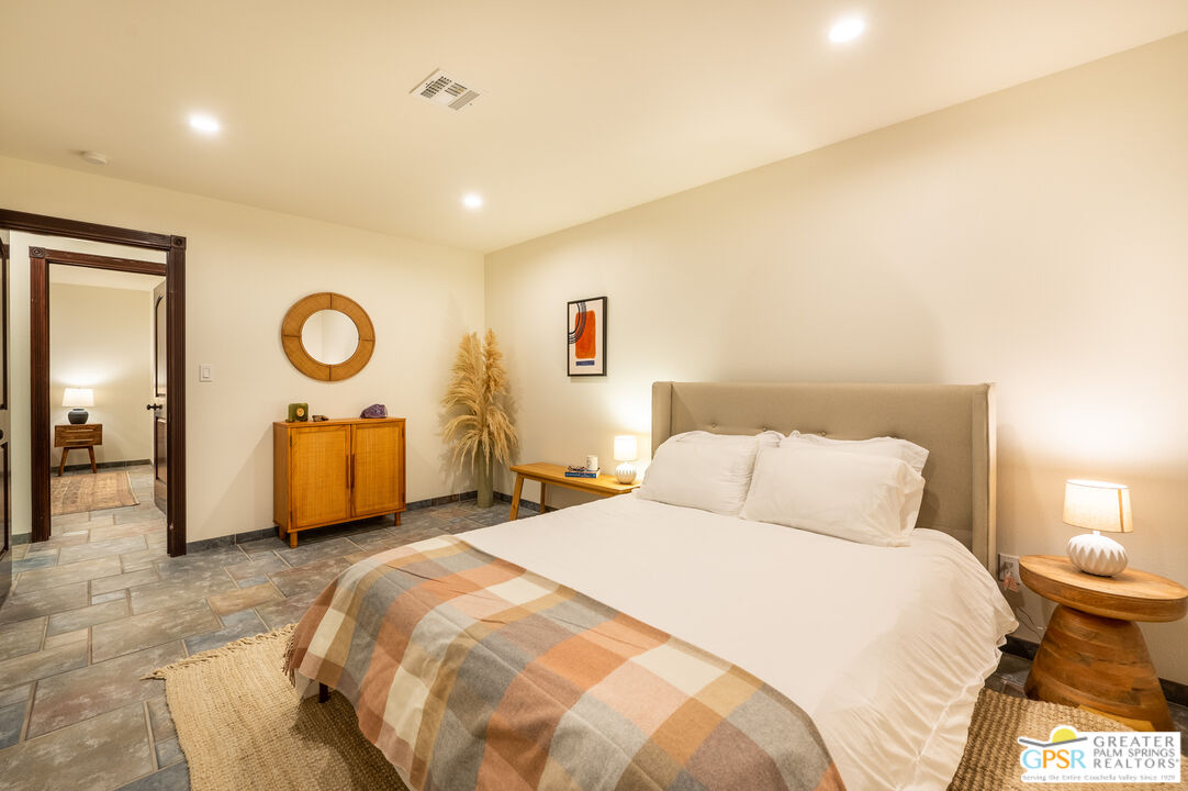 54045 Ridge Road Yucca Valley, CA 92284 - Photo 13 of 46 a bedroom with a bed and a chandelier