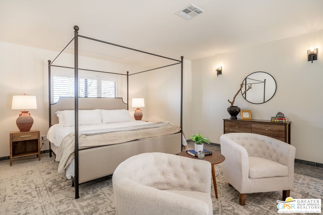 54045 Ridge Road Yucca Valley, CA 92284 - Photo 18 of 46 a bedroom with a bed a chandelier and couch