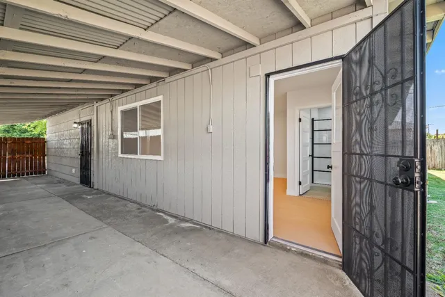 an empty room with a window and a ceiling fan