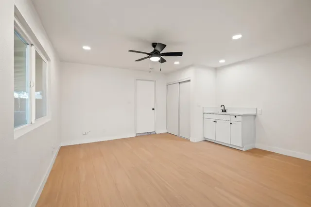 an empty room with closet and windows