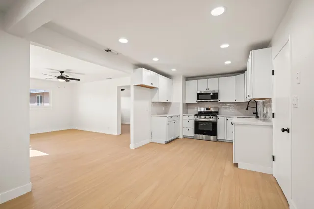 a kitchen with white cabinets and stainless steel appliances