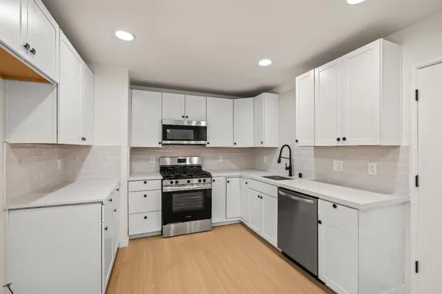 a kitchen with stainless steel appliances granite countertop a stove sink and cabinets