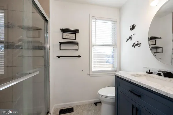 a bathroom with a granite countertop sink toilet and shower