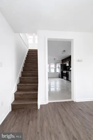 a view of a hallway with wooden floor and a living room