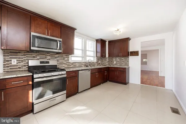 a kitchen with stainless steel appliances granite countertop a stove microwave and sink