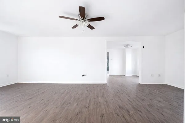 a view of a room with wooden floor and a ceiling fan