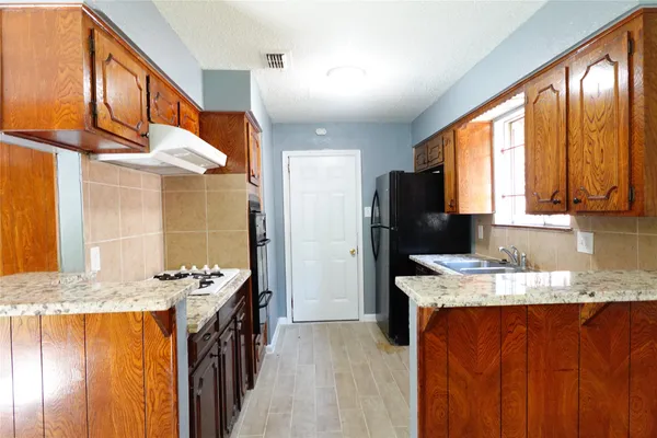 a kitchen with stainless steel appliances granite countertop a sink stove and refrigerator