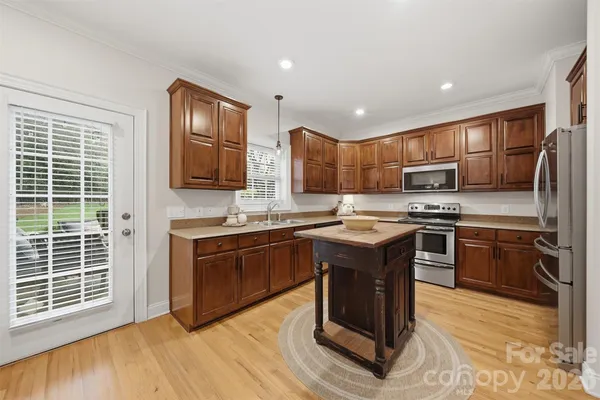 a bedroom with bed and a dresser with wooden floor