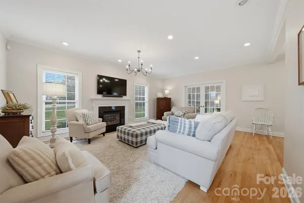 a dining room with furniture a chandelier and wooden floor