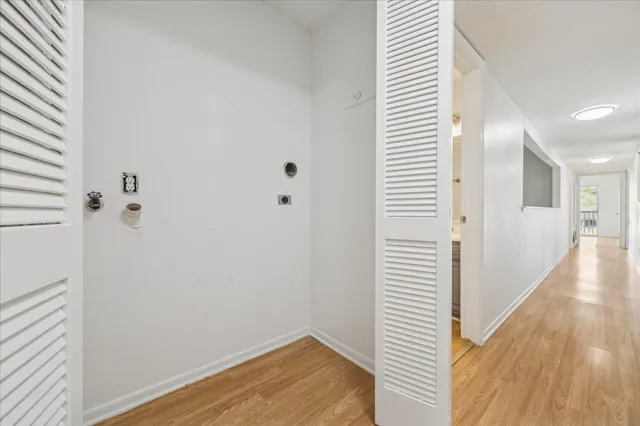 a view of a hallway with wooden floor and staircase