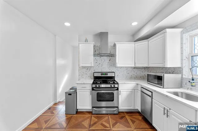 a kitchen with cabinets stainless steel appliances and a counter space