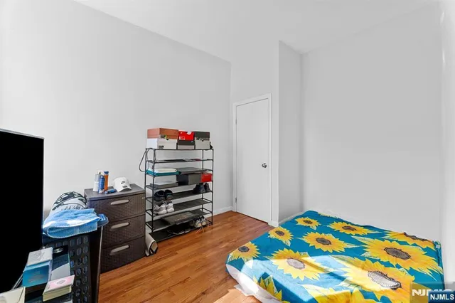 a bedroom with a bed and a wooden floor