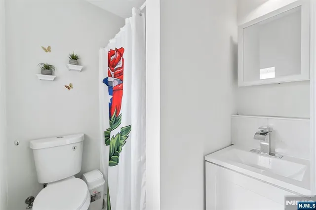 a bathroom with a toilet sink and mirror