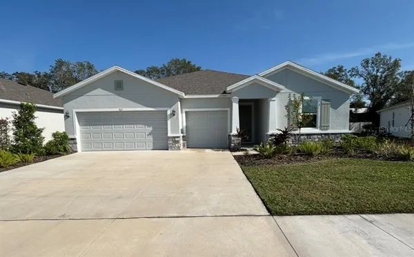 a front view of a house with a yard and garage