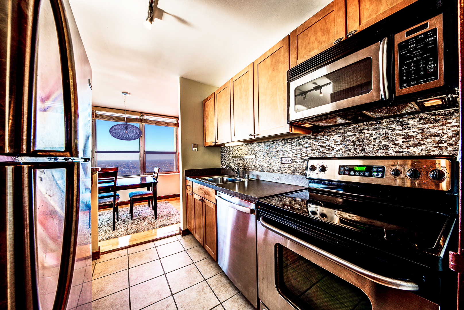 655 West Irving Park Road, Unit 3817 Chicago, IL 60613 - Photo 10 of 28 a kitchen with stainless steel appliances a stove a microwave and a cabinets
