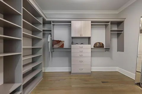 a view of walk in closet with empty racks