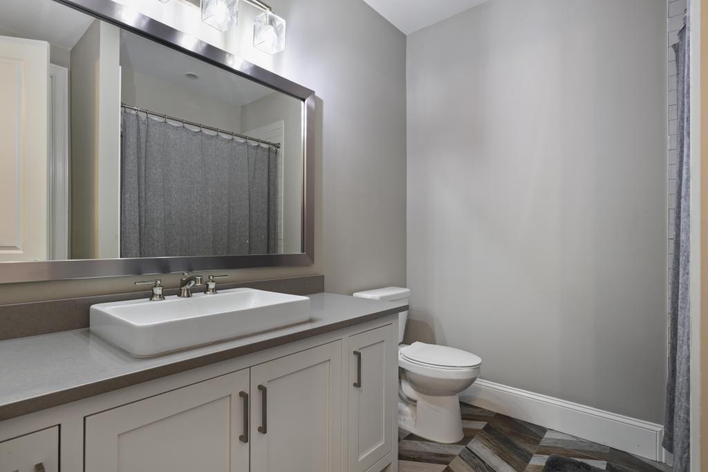 5980 Teton Way Atlanta, GA 30328 - Photo 28 of 48 a bathroom with a granite countertop sink a toilet and a mirror