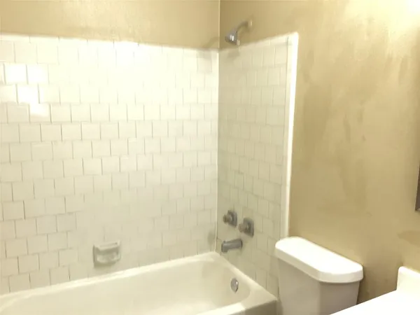 a bath room with a toilet and a bath tub