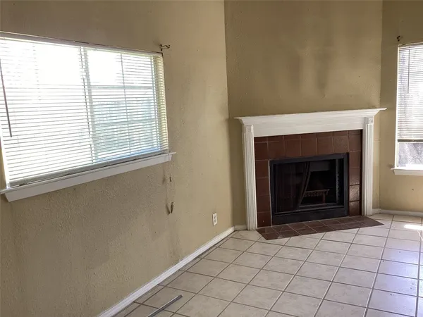 a view of an empty room with window and fire place