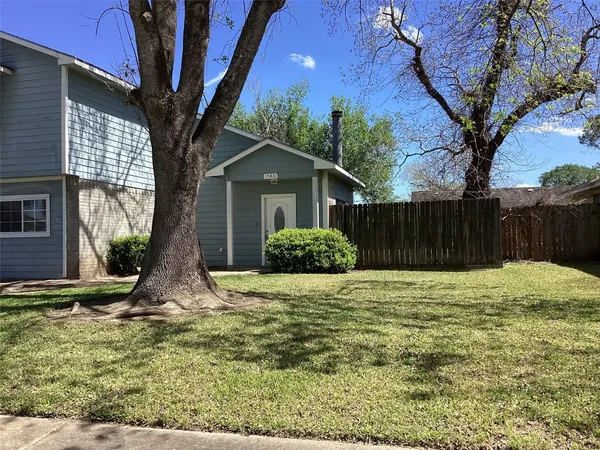 a white house that has a tree in front of it