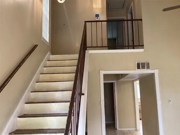 a view of staircase with white walls and a window