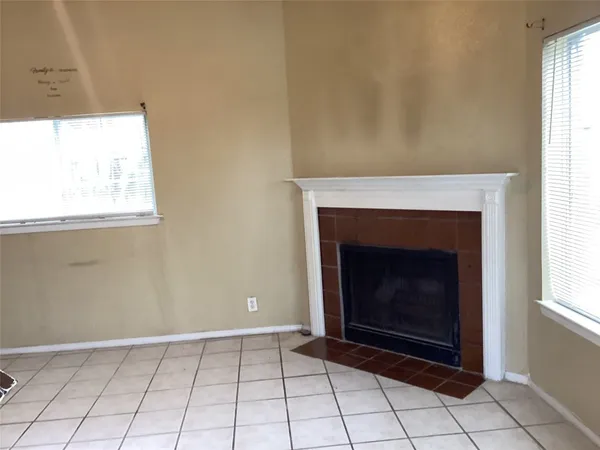 a view of an empty room with window and fire place