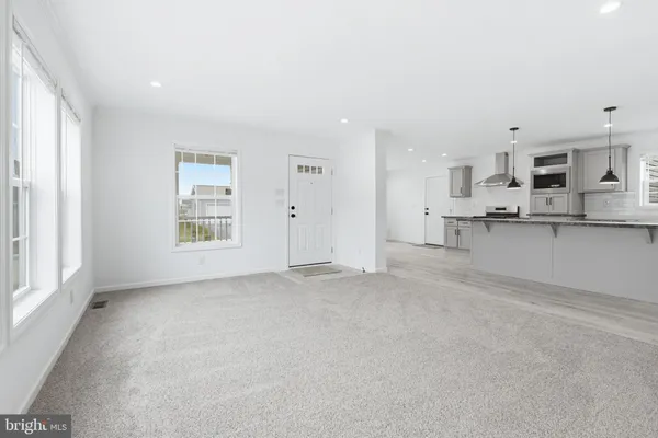 a view of a kitchen with kitchen island a sink wooden floor and a window