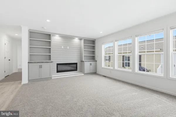 an empty room with a fireplace and windows