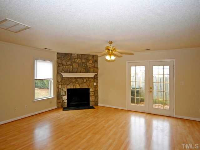 5952 Shady Grove Circle Raleigh, NC 27609 - Photo 13 of 25 a view of an empty room with a fireplace and a window