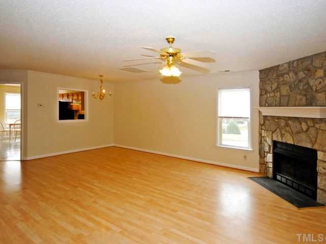 5952 Shady Grove Circle Raleigh, NC 27609 - Photo 16 of 25 a view of an empty room with chandelier fan and a fireplace