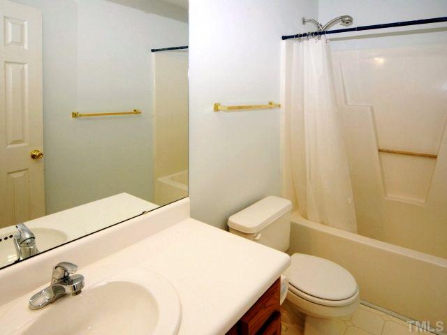 5952 Shady Grove Circle Raleigh, NC 27609 - Photo 21 of 25 a bathroom with a sink a toilet and shower curtain