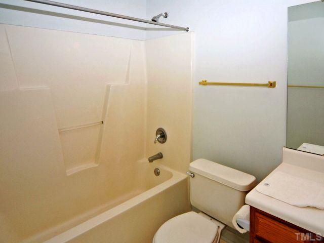 5952 Shady Grove Circle Raleigh, NC 27609 - Photo 22 of 25 a white toilet sitting next to a bath tub and a shower