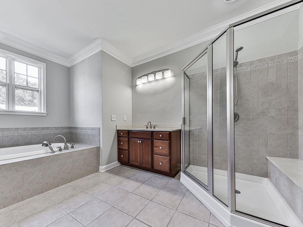 626 Laurel Crossing Canton, GA 30114 - Photo 34 of 77 a bathroom with a tub sink and mirror