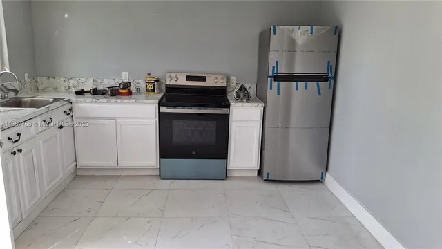 a kitchen with a refrigerator sink stove and cabinets