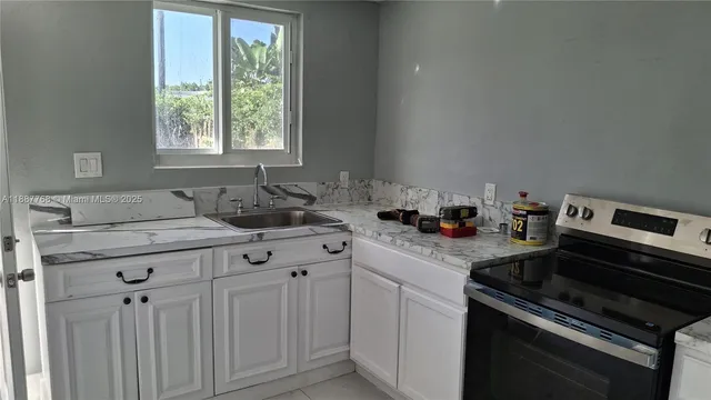 a kitchen with granite countertop white cabinets and white appliances