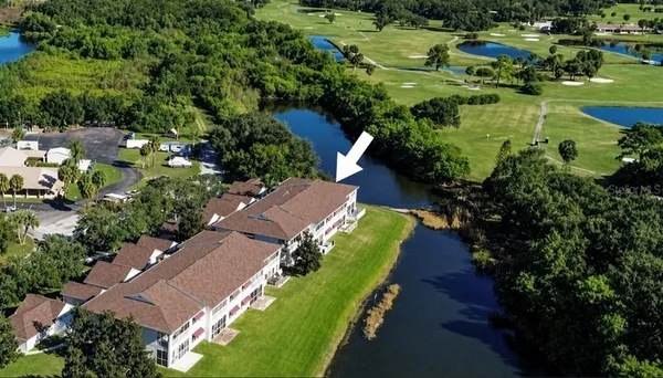 an aerial view of a house with a garden and lake view