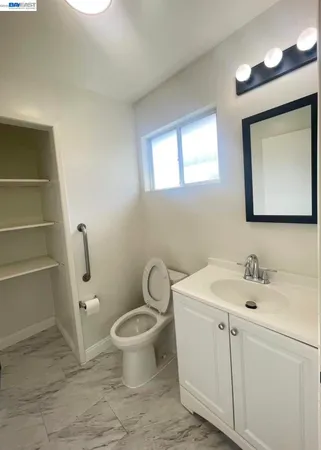 a bathroom with a toilet sink and mirror