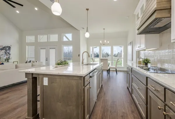 a kitchen with counter top space sink stove and wooden floor