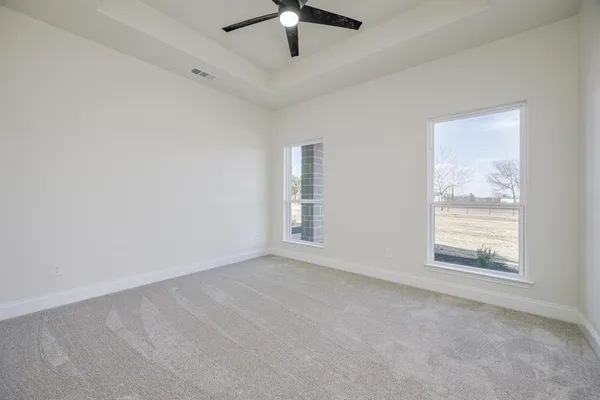 an empty room with a window and a fan