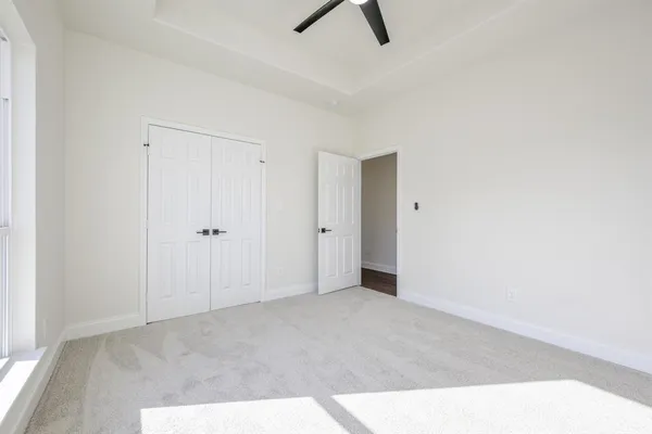 a view of a room with a ceiling fan and window