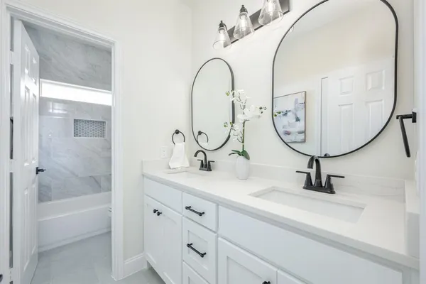 a bathroom with a sink a bathtub and a mirror