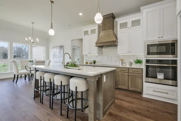 a kitchen with a table chairs microwave and cabinets