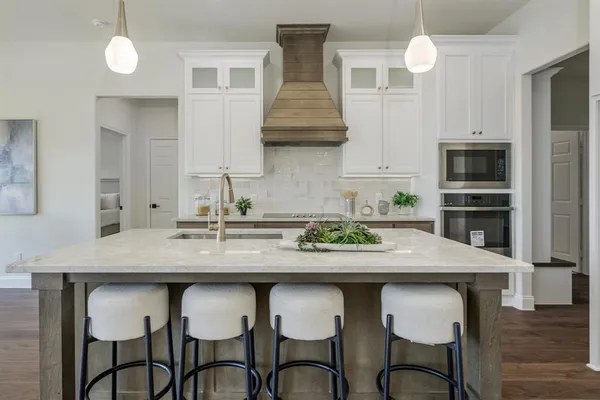 a kitchen with stainless steel appliances a table and chairs in it