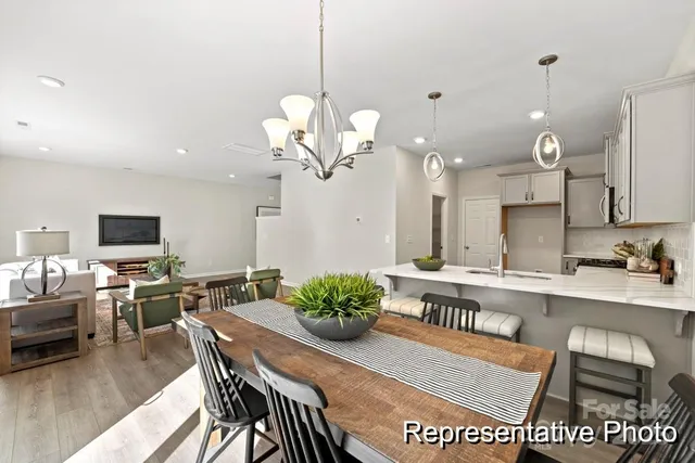 a dining room filled chandelier and kitchen view