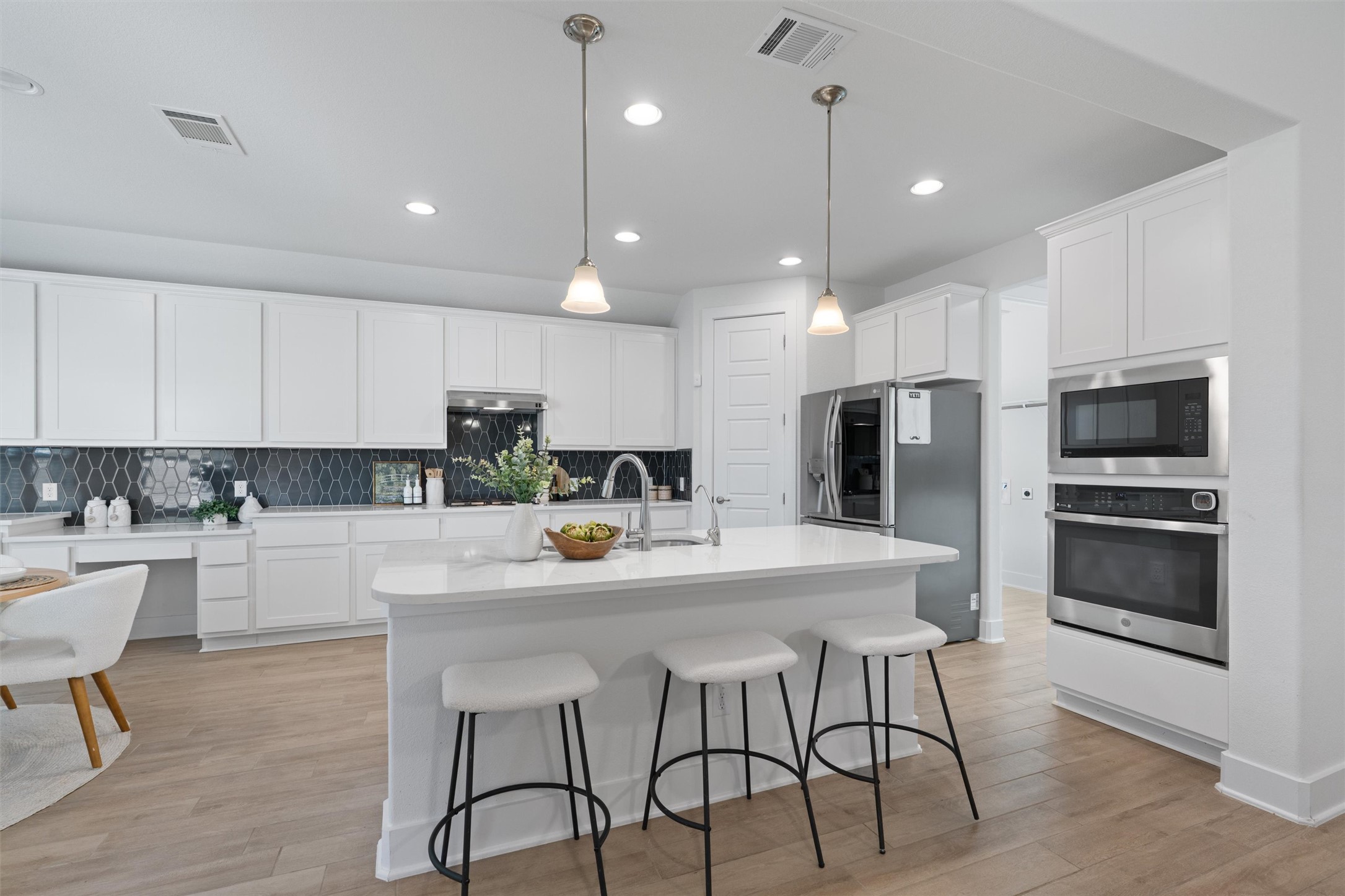 109 Wake Lane Georgetown, TX 78633 - Photo 3 of 34 a kitchen with stainless steel appliances a dining table chairs microwave and sink